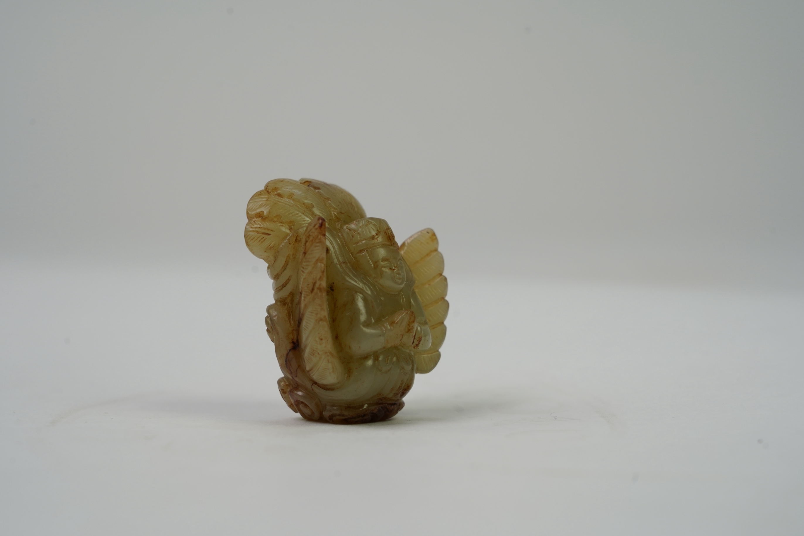 A Chinese archaistic celadon and russet jade figure a winged female immortal bird